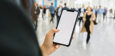 Woman hand holding black cellphone with white screen at a trade fair, copyspace for your individual text.- Stock Photo or Stock Video of rcfotostock | RC Photo Stock