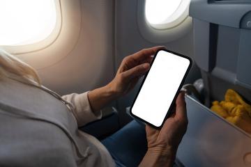 Woman hands on airplane holding mobile phone in hands with blank desktop screen by the window to take a photo Mockup image with copy space- Stock Photo or Stock Video of rcfotostock | RC Photo Stock