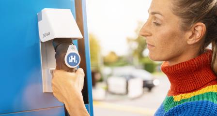 woman holds a fuel dispenser with hydrogen logo on gas station to fill up her car. h2 combustion engine for emission free eco friendly transport concept image : Stock Photo or Stock Video Download rcfotostock photos, images and assets rcfotostock | RC Photo Stock.: