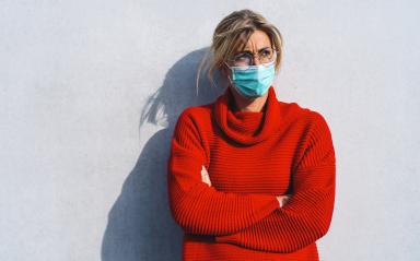 woman in a red sweater stands against a neutral background, wearing a turquoise face mask and round glasses, with her arms crossed because she is annoyed by the Corona pandemic  : Stock Photo or Stock Video Download rcfotostock photos, images and assets rcfotostock | RC Photo Stock.: