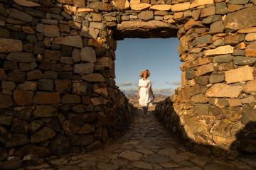 Woman in a white dress and straw hat walking through an ancient stone archway : Stock Photo or Stock Video Download rcfotostock photos, images and assets rcfotostock | RC Photo Stock.: