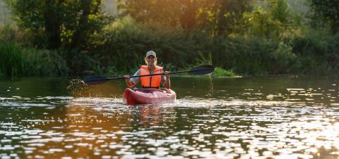 woman in an orange life vest joyfully kayaks on a serene river at sunset, surrounded by lush greenery at summer in germany. Kayak Water Sports concept image- Stock Photo or Stock Video of rcfotostock | RC Photo Stock