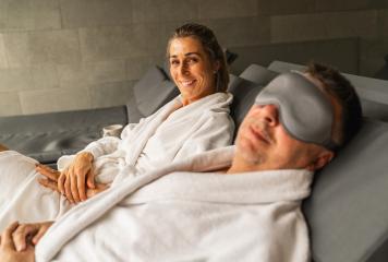 Woman in spa gown smiling, man beside her with sleeping mask, both reclining : Stock Photo or Stock Video Download rcfotostock photos, images and assets rcfotostock | RC Photo Stock.: