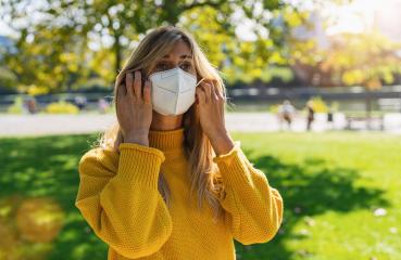 Woman in the park puts on a medical anti virus protection knN95 FFP2 face mask to prevent others from corona virus COVID-19 and SARS cov 2 infection at spring  Woman using protective face mask- Stock Photo or Stock Video of rcfotostock | RC Photo Stock