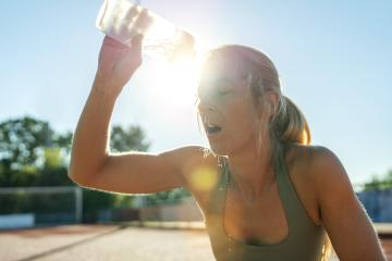 Woman pouring water on face after workout, sun flare, sports bottle, refreshing : Stock Photo or Stock Video Download rcfotostock photos, images and assets rcfotostock | RC Photo Stock.: