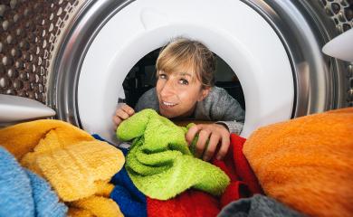 Woman Reaching Inside a washing machine or dryer at Laundry : Stock Photo or Stock Video Download rcfotostock photos, images and assets rcfotostock | RC Photo Stock.: