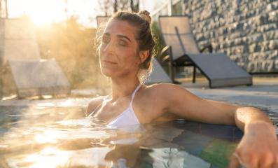 Woman relaxing in hot tub with sunflare, serene expression at wellness hotel : Stock Photo or Stock Video Download rcfotostock photos, images and assets rcfotostock | RC Photo Stock.: