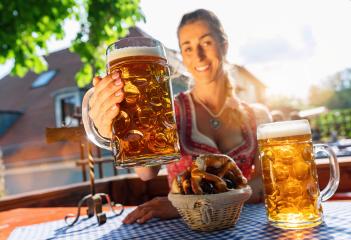 Woman sitting in Beer garden or oktoberfest, cheers with beer mug and enjoying the sun- Stock Photo or Stock Video of rcfotostock | RC Photo Stock