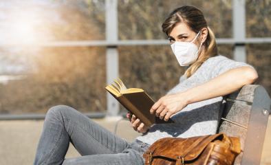 Woman sitting on bench in the City and read a book with protection mask to prevent others from corona COVID-19 and SARS cov 2 infection. social distancing concept image- Stock Photo or Stock Video of rcfotostock | RC-Photo-Stock