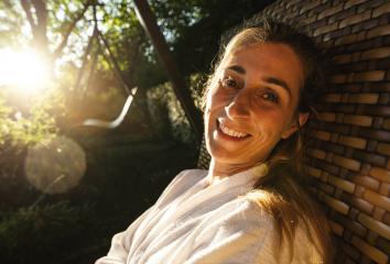 Woman smiling on a garden swing, sun shining through the trees- Stock Photo or Stock Video of rcfotostock | RC Photo Stock