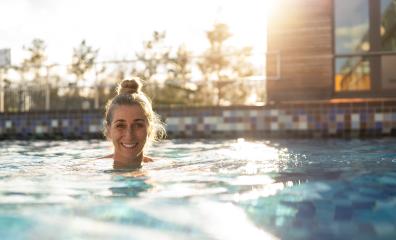 Woman swimming in a pool at sunset in a hotel, with a happy expr- Stock Photo or Stock Video of rcfotostock | RC Photo Stock