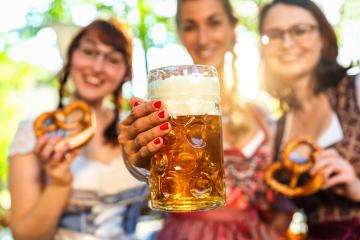 Woman toasting to the camera with glass of beer with girl friends in Bavarian beer garden or oktoberfest- Stock Photo or Stock Video of rcfotostock | RC Photo Stock