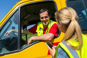 Woman using smartphone talking to a smiling tow truck driver sitting in yellow truck. Roadside assistance concept image. : Stock Photo or Stock Video Download rcfotostock photos, images and assets rcfotostock | RC Photo Stock.: