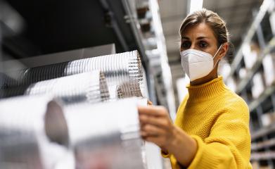 woman with face mask examines silver ventilation tubes in a warehouse or store setting.  Corona safety Concept image : Stock Photo or Stock Video Download rcfotostock photos, images and assets rcfotostock | RC Photo Stock.: