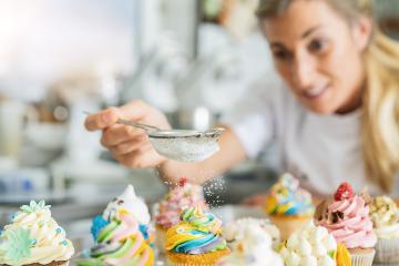 women in pastry bakery as confectioner sprinkles powdered sugar in a colander as topping on a colorful muffin : Stock Photo or Stock Video Download rcfotostock photos, images and assets rcfotostock | RC Photo Stock.: