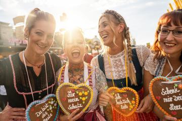 women in traditional Bavarian clothes dirndl with a Schenk mir dein Herz, Für mein Schatz, Ich hab dich lieb (German: Give me your heart, For my sweetheart) written on gingerbreads heart, Oktoberfest- Stock Photo or Stock Video of rcfotostock | RC Photo Stock