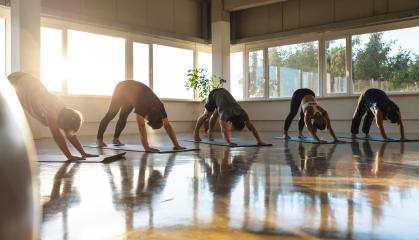 Yoga class in downward dog position, sunlit gym with reflective floor- Stock Photo or Stock Video of rcfotostock | RC Photo Stock