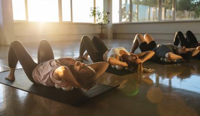 Yoga participants in a resting pose on mats with massage ball in a sun-filled studio- Stock Photo or Stock Video of rcfotostock | RC Photo Stock
