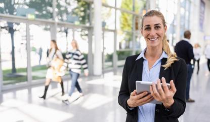 young beautiful businesswoman at a trade fair, holding tablet, with copy space for individual text- Stock Photo or Stock Video of rcfotostock | RC Photo Stock