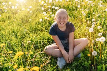 young girl sitting in a sunny field full of dandelions, smiling happily. The sun is shining brightly, creating a warm and vibrant atmosphere, capturing the joy of nature and childhood. : Stock Photo or Stock Video Download rcfotostock photos, images and assets rcfotostock | RC Photo Stock.: