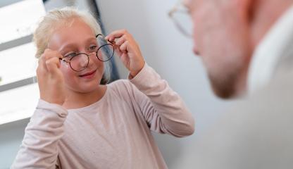 Young girl trying on new glasses and smiling. Optician examines how a young girl tries on glasses at a eyewear shop.  : Stock Photo or Stock Video Download rcfotostock photos, images and assets rcfotostock | RC Photo Stock.: