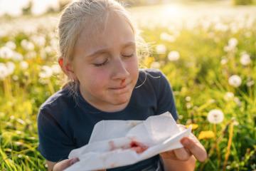 young girl with a nosebleed holding a blood-stained tissue while sitting in a field of dandelions, looking distressed. The image captures the outdoor setting and the health concern. : Stock Photo or Stock Video Download rcfotostock photos, images and assets rcfotostock | RC Photo Stock.: