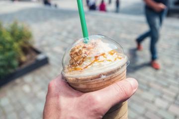 young man holding a ice caramel coffee plastic cup in the pedestrian zone. POV image - Stock Photo or Stock Video of rcfotostock | RC Photo Stock