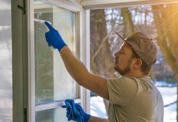 young man is using a rag and squeegee while cleaning windows.- Stock Photo or Stock Video of rcfotostock | RC Photo Stock