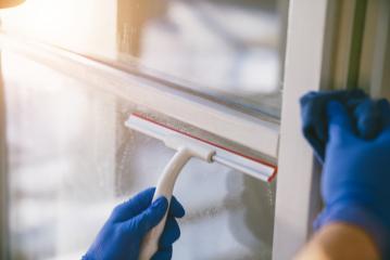 young man is using a rag and squeegee while cleaning windows.- Stock Photo or Stock Video of rcfotostock | RC-Photo-Stock