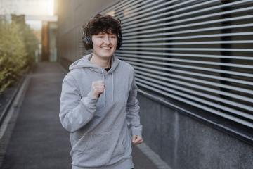 young person runs and makes fitness workout for good health and listing to music on earphones - Stock Photo or Stock Video of rcfotostock | RC Photo Stock