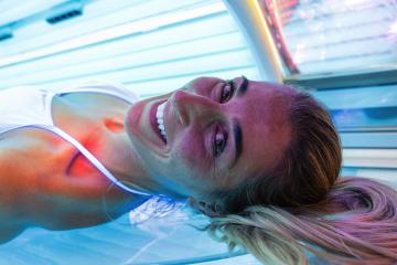 young woman at laying on solarium bed and get brown skin tone ready for summer- Stock Photo or Stock Video of rcfotostock | RC Photo Stock