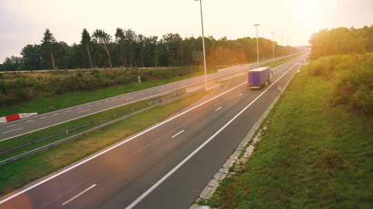 Commercial Truck with Cargo Trailer drives through empty Highway. Truck is White and blue. Sun shining in the background- Stock Photo or Stock Video of rcfotostock | RC Photo Stock