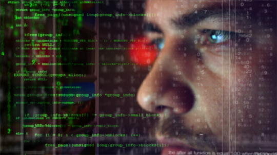 Male hacker working on a computer for cyber attack while green binary hacking code characters reflect on his face in a dark office room - industry 4.0 concept- Stock Photo or Stock Video of rcfotostock | RC-Photo-Stock