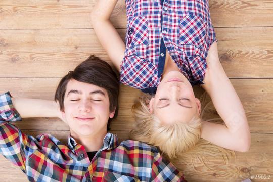 A boy and a girl wearing plaid shirts lying on a wooden floor with their eyes closed, smiling peacefully, enjoying a relaxed and happy moment together  : Stock Photo or Stock Video Download rcfotostock photos, images and assets rcfotostock | RC Photo Stock.: