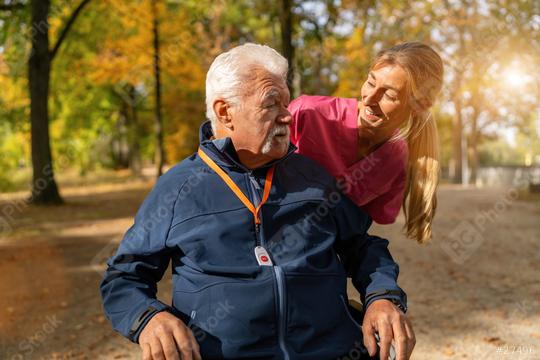 A caregiver in pink assists a joyful elderly man in a wheelchair, who wears a blue jacket with an SOS button.  : Stock Photo or Stock Video Download rcfotostock photos, images and assets rcfotostock | RC Photo Stock.: