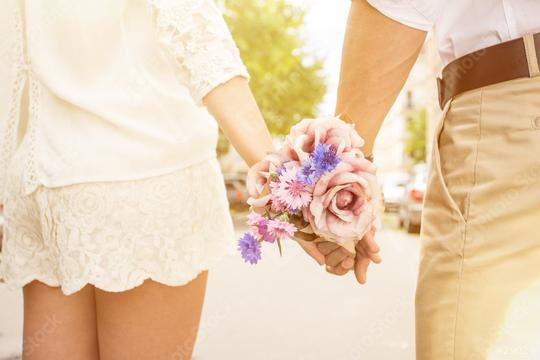 A couple holding hands in a romantic setting, with one person holding a bouquet of pink roses and purple flowers, symbolizing love and affection, in soft, warm lighting outdoors  : Stock Photo or Stock Video Download rcfotostock photos, images and assets rcfotostock | RC Photo Stock.: