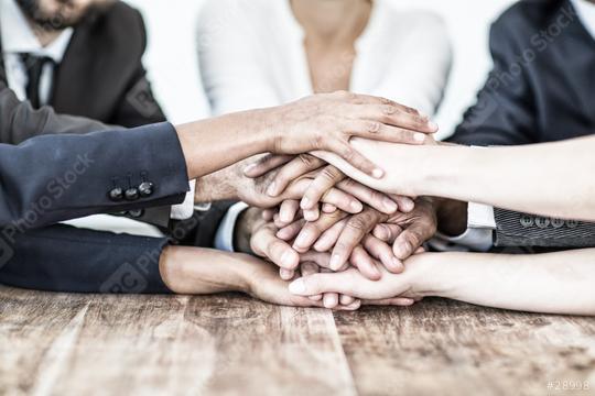 A diverse group of hands stacked together over a wooden table, symbolizing teamwork, unity, collaboration, and solidarity in a professional or community setting  : Stock Photo or Stock Video Download rcfotostock photos, images and assets rcfotostock | RC Photo Stock.: