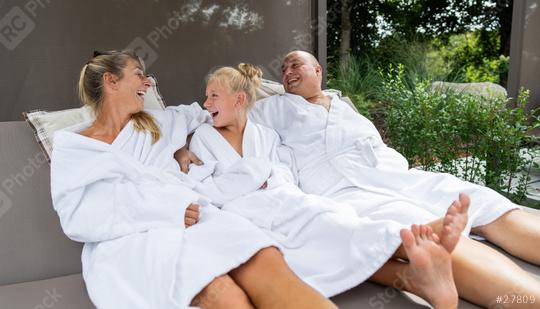 A family, joyfully laughing and cuddling in a spa lounge at a hotel, wearing white robes surrounded by greenery  : Stock Photo or Stock Video Download rcfotostock photos, images and assets rcfotostock | RC Photo Stock.: