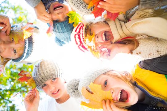 A group of joyful children wearing cozy winter hats and scarves, holding colorful autumn leaves, laughing and playing outdoors, surrounded by vibrant fall foliage and natural light  : Stock Photo or Stock Video Download rcfotostock photos, images and assets rcfotostock | RC Photo Stock.: