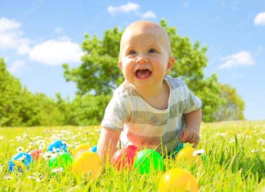 A happy baby crawling on a grassy field with colorful plastic balls scattered around, surrounded by wildflowers under a sunny blue sky and green trees in the background.  : Stock Photo or Stock Video Download rcfotostock photos, images and assets rcfotostock | RC Photo Stock.: