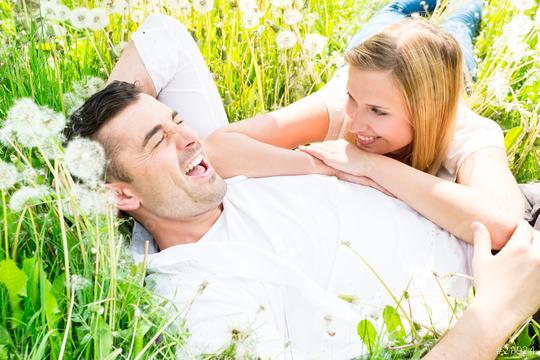 A happy couple lying in a field of dandelions, laughing and enjoying a sunny day, surrounded by lush green grass and bright natural light, exuding love, joy, and relaxation  : Stock Photo or Stock Video Download rcfotostock photos, images and assets rcfotostock | RC Photo Stock.: