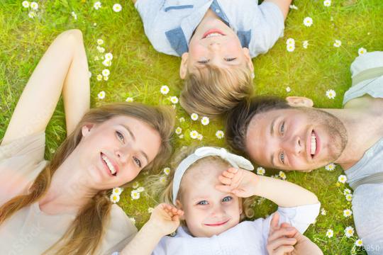 A happy family of four lies on the grass surrounded by daisies, smiling and enjoying quality time outdoors, creating a moment of togetherness, relaxation, and nature bonding
  : Stock Photo or Stock Video Download rcfotostock photos, images and assets rcfotostock | RC Photo Stock.: