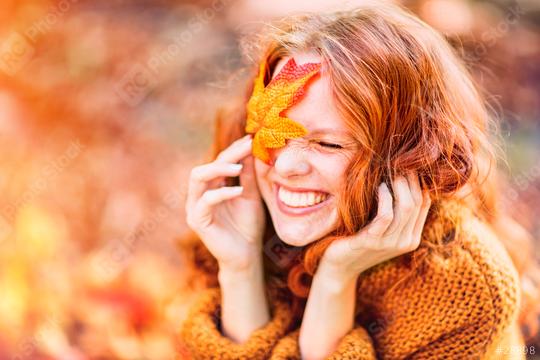 A joyful red-haired woman in an autumn setting, smiling with a vibrant orange leaf covering one eye, wearing a cozy sweater and surrounded by warm fall tones and sunlight
  : Stock Photo or Stock Video Download rcfotostock photos, images and assets rcfotostock | RC Photo Stock.: