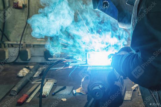 A man welder with construction gloves and a welding mask hard work and welds with a welding machine metal in workshop, close up  : Stock Photo or Stock Video Download rcfotostock photos, images and assets rcfotostock | RC Photo Stock.: