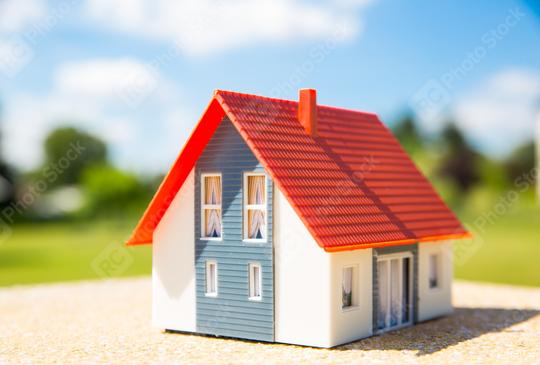 A miniature house with a red roof and blue walls sits on a sunny outdoor surface, symbolizing real estate, home ownership, and cozy living in a bright, natural environment  : Stock Photo or Stock Video Download rcfotostock photos, images and assets rcfotostock | RC Photo Stock.: