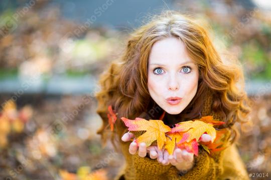 A red-haired woman in an autumn setting, holding colorful fall leaves in her hands, blowing them playfully, surrounded by warm tones and a blurred natural background  : Stock Photo or Stock Video Download rcfotostock photos, images and assets rcfotostock | RC Photo Stock.: