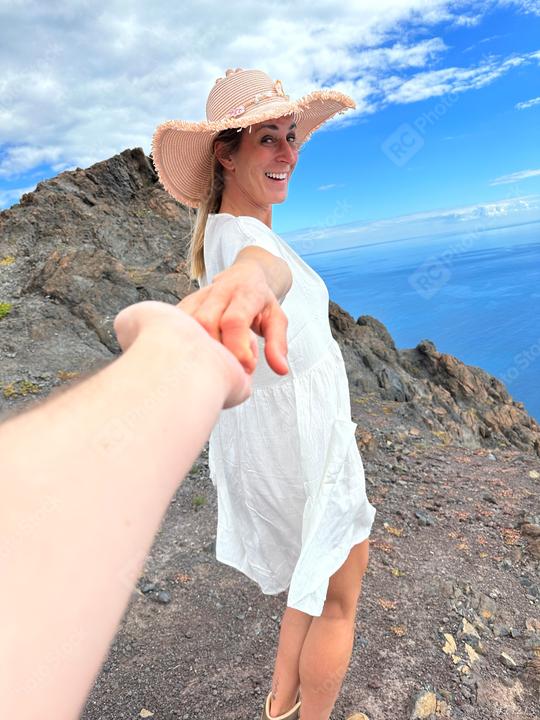 A smiling woman in a white dress and sunhat holds hands with someone, standing on a rocky cliff with a stunning ocean view and blue sky in the background.
  : Stock Photo or Stock Video Download rcfotostock photos, images and assets rcfotostock | RC Photo Stock.: