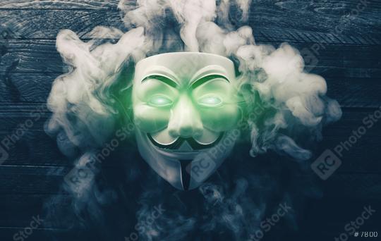 AACHEN, GERMANY FEBRUARY, 2017: Vendetta mask with light eyes and smoke on wooden background. This mask is a well-known symbol for the online hacktivist group Anonymous  : Stock Photo or Stock Video Download rcfotostock photos, images and assets rcfotostock | RC Photo Stock.: