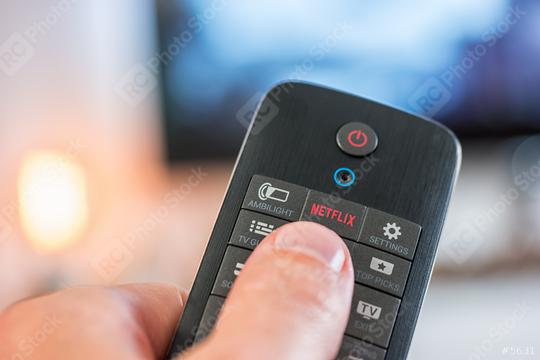 AACHEN, GERMANY OCTOBER, 2017:Man holds a remote control and push a Netflix button. Netflix Inc. is an American company founded specializes in and provides streaming media and video on demand online.  : Stock Photo or Stock Video Download rcfotostock photos, images and assets rcfotostock | RC Photo Stock.: