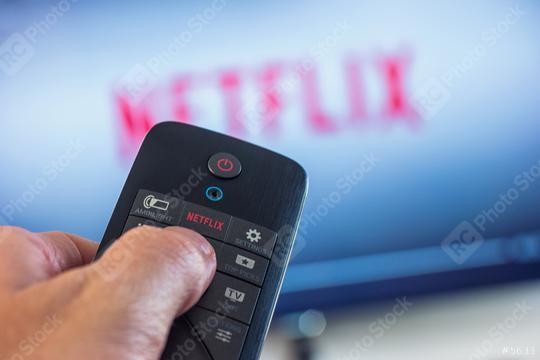 AACHEN, GERMANY OCTOBER, 2017:Man holds a remote control and selects a movie from Netflix. Netflix is an entertainment company, specializes in and provides streaming media and video on demand online.  : Stock Photo or Stock Video Download rcfotostock photos, images and assets rcfotostock | RC Photo Stock.: